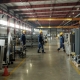 Manufacturing facility in the United States with workers walking through the frame