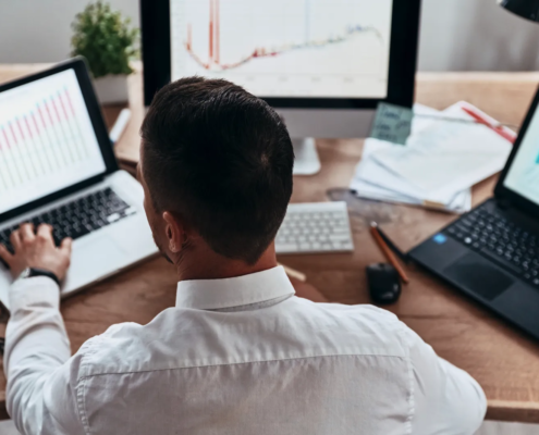 Analyst reviewing maps and charts that visualize site selection data