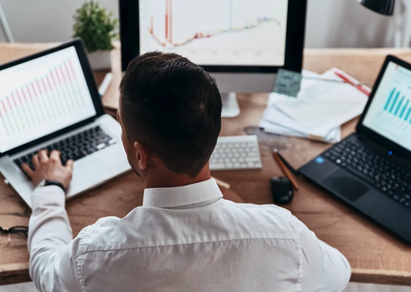 Analyst reviewing maps and charts that visualize site selection data